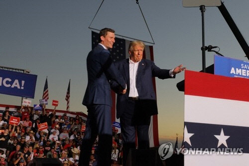 도널드 트럼프 전 미국 대통령이 9일(현지시간) 애리조나주 메사에서 열린 '세이브 아메리카' 집회에 참가해 중간선거에 나서는 공화당 상원 후보 블레이크 매스터스와 악수하고 있다.  메사=로이터 연합뉴스